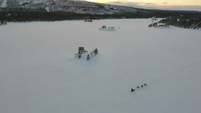 Aerial view of a dog sled on a remote frozen lake