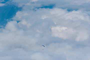 The paraglider flies over the clouds in the Caucasus Mountains