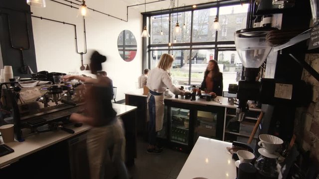  Time lapse of busy staff members serving customers in city coffee shop