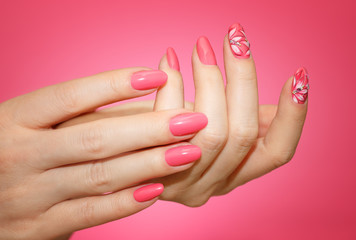 Manicured woman's nails with pink nailart with flowers.