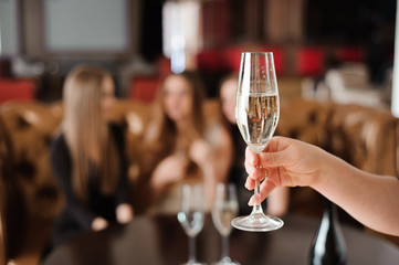 glass of champagne on the background of friends at a party