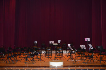 Empty music stand and chairs on stage