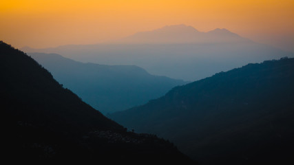 Nepal, March 2017: Layers of hazy mountains fading into the distance at sunrise. Taken from Ulleri looking down the valley towards Birethanti. Annapurna region.