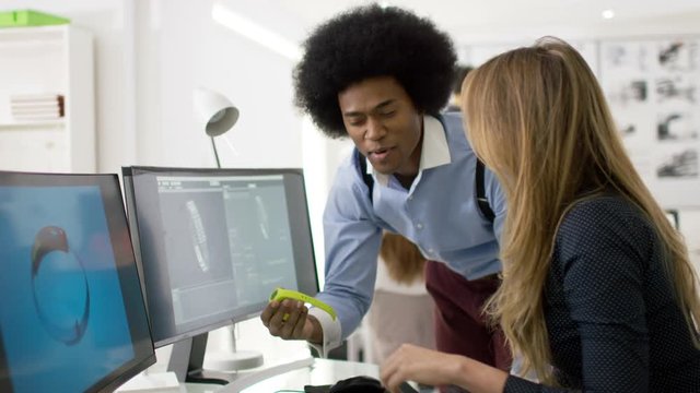  Creative technology designers working on computer, designing smart watch