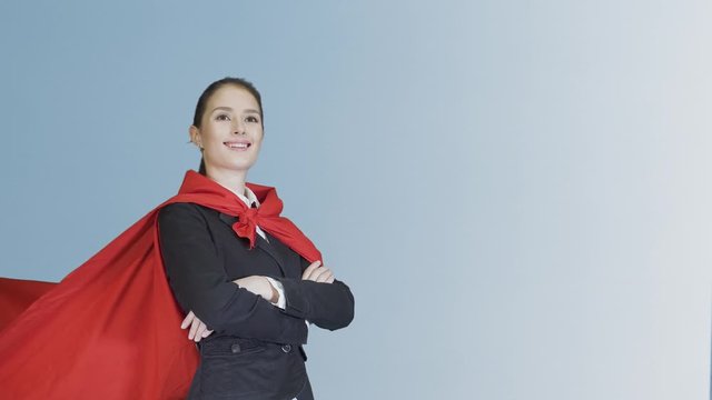 triumphantly beautiful young woman business leader is dressed in red Cape on a white background
