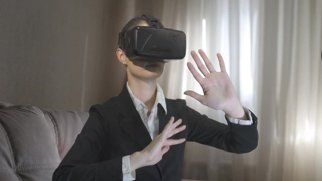 happy smiling young beautiful girl l getting experience using VR-headset glasses of virtual reality at home in the house apartment