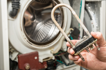 Obraz premium Repair old laundry washer. Extracting the broken heater.