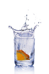 Splash in glass of blue water with orange slice