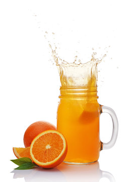 Splash in glass jar of juice with falling slice of orange
