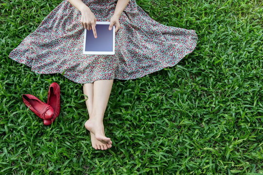 Woman relaxing and using tablet in Spring, Top view, blank screen is clipping path
