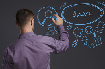 Business, Technology, Internet and network concept. A young businessman writes on the blackboard the word: Share