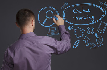 Business, Technology, Internet and network concept. A young businessman writes on the blackboard the word: Online training