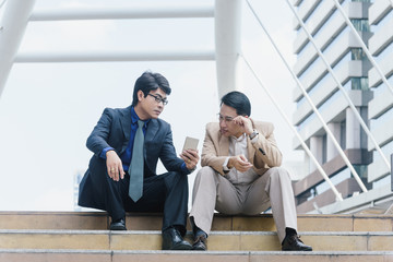 Busy business people using a smartphone in the city, to communicate or ecommerce trading.