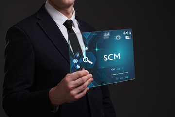 Business, Technology, Internet and network concept. Young businessman working on a virtual screen of the future and sees the inscription: SCM