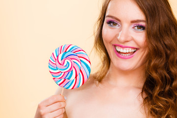 Woman holds colorful lollipop candy in hand