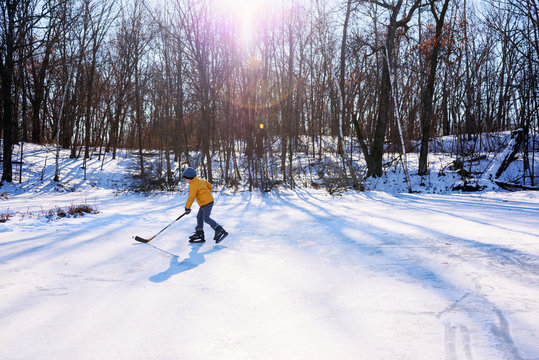 Young boy playing hockey on snowy landscape