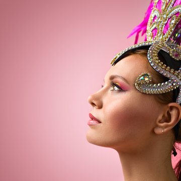 Beautiful Girl in carnival  headdress on pink background.