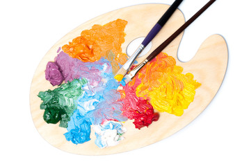Colored artist's oil paint and brushes on the wooden palette