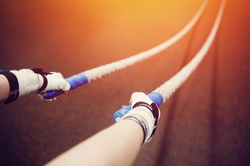 close-up girl is engaged with a rope in the gym. The concept of fitness and crossfit.