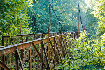 Old unused suspension bridge across the ravine
