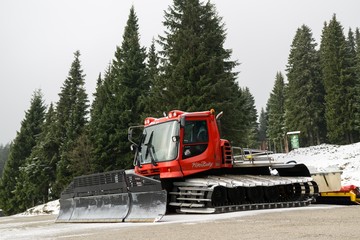 Snow plow on the hill with trees. Slovakia