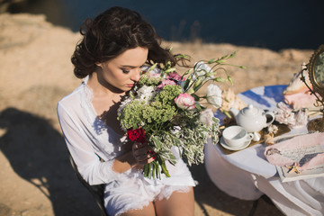 Bride in lingerie. Holds the Bridal bouquet . Charges of the bride, bride's morning.