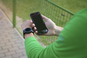 Man hand holding contemporary modern smartphone. Blank display replaceable with needed design.Vertical. Portrait mode mockup.Smartwatch mockup.