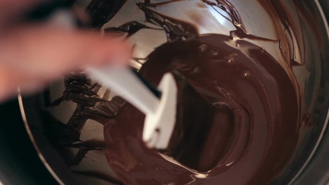 close up shot of Chef baker mixing sweet delicious organic melted chocolate in bowl