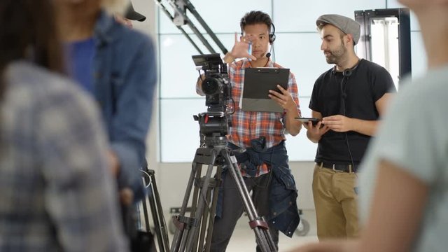  Behind the scenes with TV or film  production crew working together on set. 