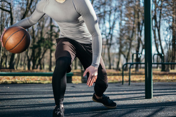 Man dribbling basketball in park, Minsk, Belarus
