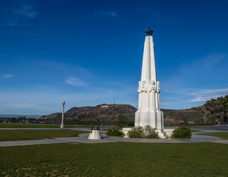 Astronomers Monument At Griffith Observatory With Hollywood Sign On Background - Los Angeles, California, USA