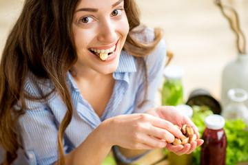 Closeup view from above of a woman eating brasil nuts with healthy food on the background