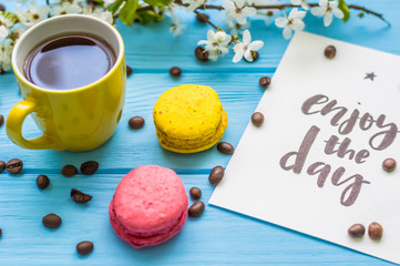 Stil life with macarons and coffee on the wooden background