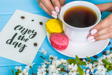 Stil life with macarons and coffee on the wooden background