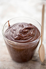 Chocolate pudding in glass with wooden spoon