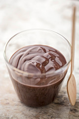 Chocolate pudding in glass with wooden spoon