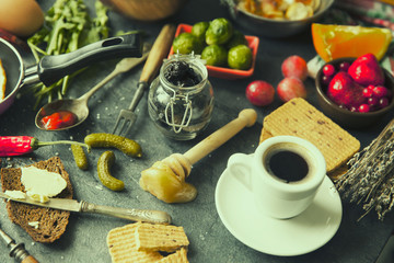 Table with food in breakfast or lunch: omelette, cabbage, oil, chili, ketchup, arugula, onion, garlic, noodles, cucumber, coffee, biscuits, orange, bread and butter