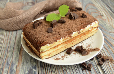 Tiramisu is classical Italian cake on the basis of a biscuit. Cake is on a wooden table.
