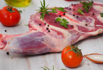 Fresh and raw meat. Leg of lamb on wood background