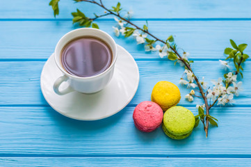 Stil life with macarons and coffee on the wooden background