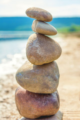Fototapeta na wymiar Photo of five stones balanced on top of eachother on a beach