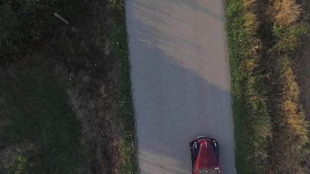 Aerial view of red oldtimer. Red oldtimer moving on the road.Oldtimer is driving on the asphalt road . Aerial top view
