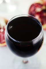 Organic pomegranate wine on white wooden table.