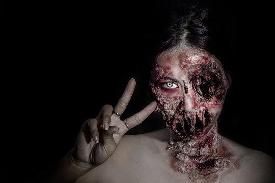  horrible scary zombie girl on black background with copyspace