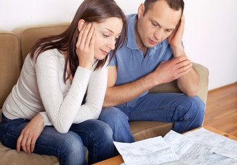 Worried couple looking at the bills.