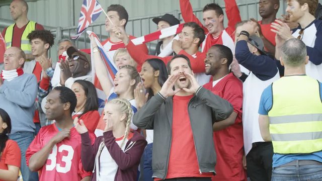  Excited sports crowd with British flag clapping & cheering on their team