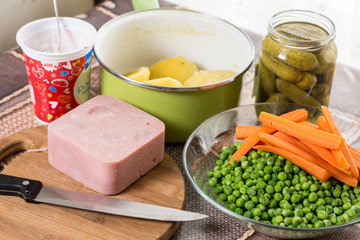 Flat lay with peeled potatoes cooked green peas carrot and ham