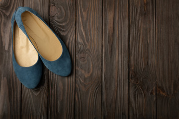 Blue women's shoes (ballerinas) on wooden background.