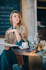Cafe table customer young woman coffee cup newspaper lifestule