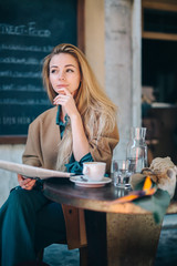 Restaurant table young woman thinking doubt coffee newspaper